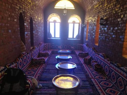 a long table in a room with chairs and windows at Ahmed Safari Camp in Bawiti