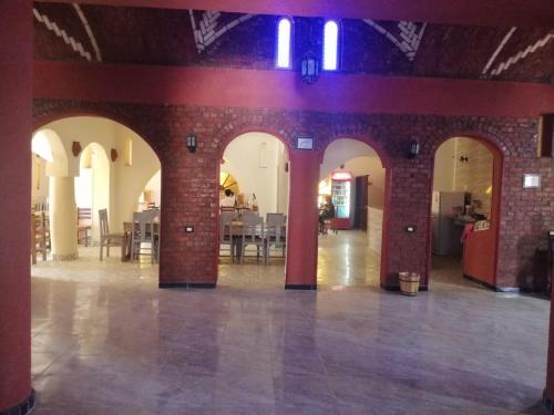 a large room with a brick wall and arches at Ahmed Safari Camp in Bawiti
