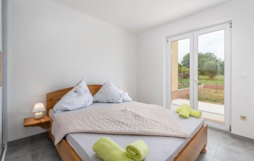 a white bedroom with a bed and a window at Apartments Smilys in Novigrad Istria