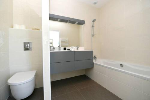 une salle de bain avec toilettes, lavabo et baignoire dans l'établissement Saint-Emilion Golf - Villa St Andrews, à Gardegan-et-Tourtirac