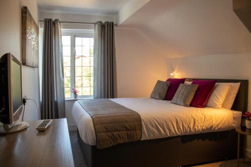 Fino Rooms في Felpham: غرفة نوم بسرير كبير ومخدات حمراء