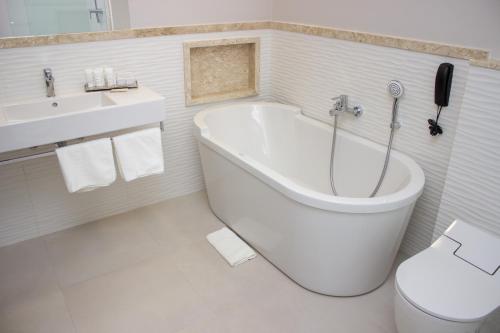 a bathroom with a tub and a toilet and a sink at VIE HOTEL in Sinop