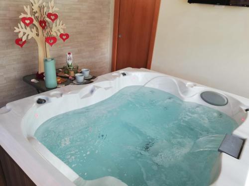 a bath tub filled with blue water in a bathroom at Villa Giuseppe Bernabei Guest House in Marino