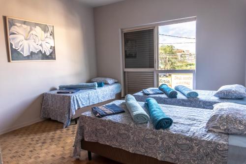 um quarto com três camas com almofadas azuis em Hostel Senhor do Café em Botucatu