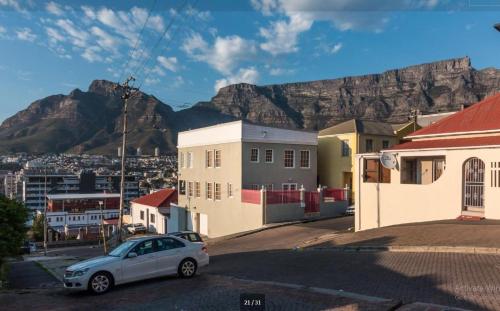 a car parked in a street with mountains in the background at Table Mountain View Villa in Cape Town