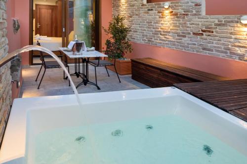 a bath tub in a room with a table at Vener Luxury Suites in Chania Town
