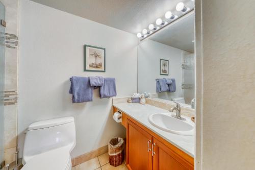 a bathroom with a toilet and a sink and a mirror at Kamaole Sands in Wailea