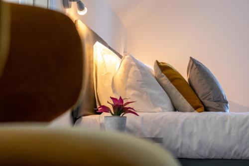a bedroom with two beds with pillows and a potted plant at Fino Rooms in Felpham