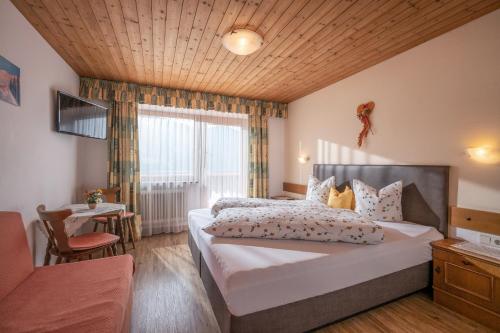 ein Schlafzimmer mit einem großen Bett und einem Fenster in der Unterkunft Gasthof Pension Berghof in Hippach