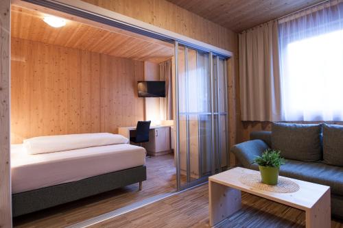 um quarto de hotel com uma cama e um sofá em Hotel Tia Smart Natur em Kaunertal