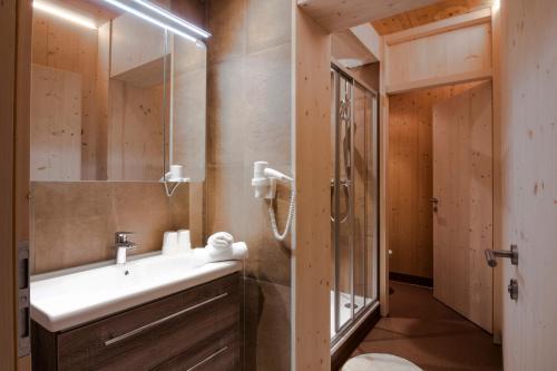 ein Badezimmer mit einem weißen Waschbecken und einer Dusche in der Unterkunft Hotel Tia Smart Natur in Kaunertal