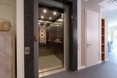- un couloir avec une porte en verre menant à une chambre dans l'établissement Strandvilla Gezeiten, à Boltenhagen