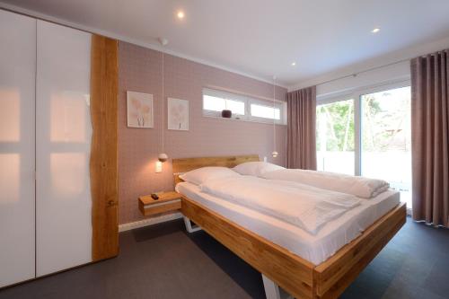 a bedroom with a large bed and a window at Strandvilla Gezeiten in Boltenhagen