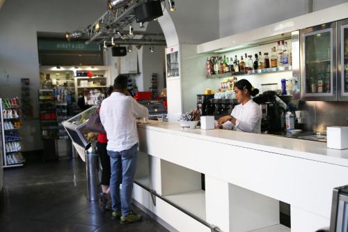 dos personas de pie en el mostrador de un bar en Biancorèroma B&B, en Roma