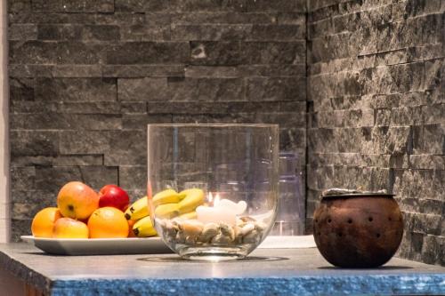 a table with a glass bowl of fruit and a candle at Appartements Monuth in Bad Hofgastein