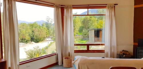 1 dormitorio con ventana grande con vistas a la calle en Las Palmas Lodge, en Olmué