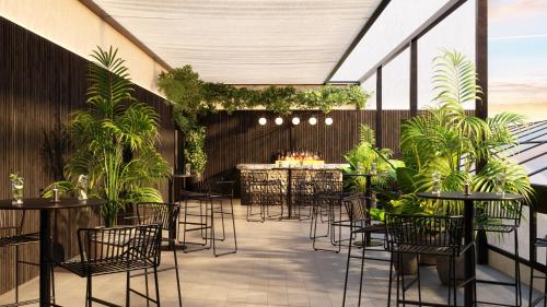 an outdoor patio with tables and chairs and plants at Radisson Blu Hotel Casablanca City Center in Casablanca