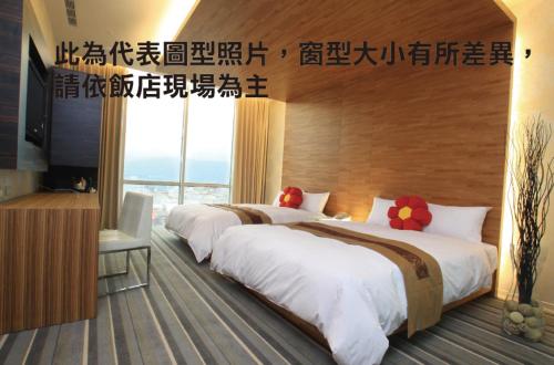 a hotel room with two beds and a large window at Yoai Hotel in Yilan City