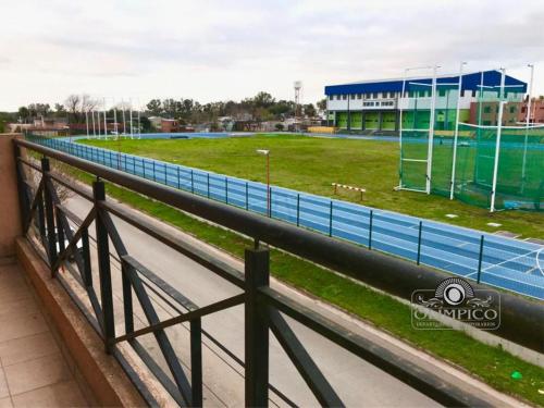 uma cerca ao lado de uma pista de corrida com um estádio em OLÍMPICO em Concepción del Uruguay