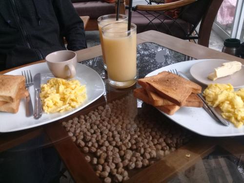 Dois pratos de ovos e torradas e um copo de sumo de laranja. em Hospedaje Rocha em Ica