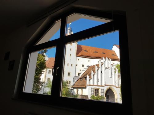 Blick auf eine Kirche durch ein Fenster in der Unterkunft Ferienwohnung Schlosswächter am Schloss Colditz in Colditz