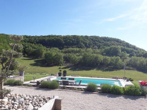 basen ze wzgórzem w tle w obiekcie GITE LA ROCHE w mieście Le Boulvé