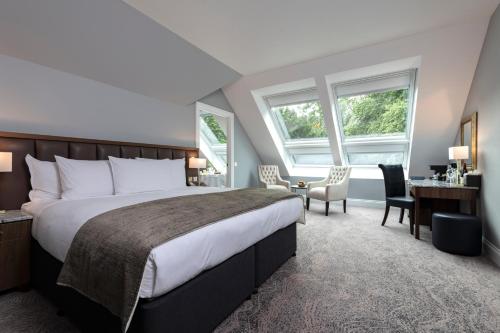 a bedroom with a large bed and a desk and chairs at Ness Walk in Inverness