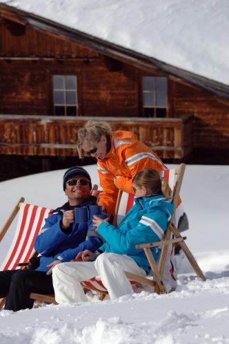 a group of people sitting in a chair in the snow at Hotel Jagdhof in Ramsau am Dachstein