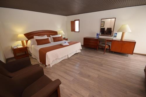 a hotel room with a bed and a desk at D'Acosta Hotel Sochagota in Paipa