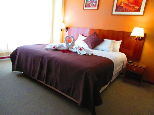 a hotel room with a bed with towels on it at Maya Inn in Puno