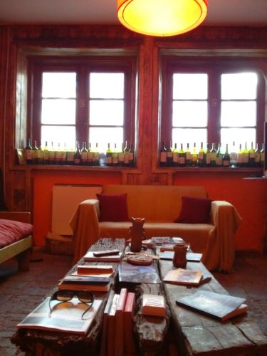 a room with a table and a couch and windows at Portezuelo del Viento - Hostel de Montaña in Las Cuevas