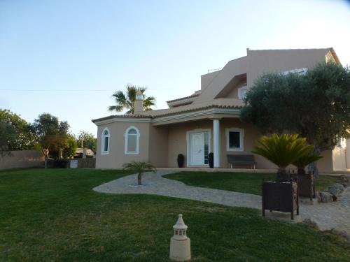 a house with a green lawn in front of it at VILLA L'ESTAQUE in Armação de Pêra