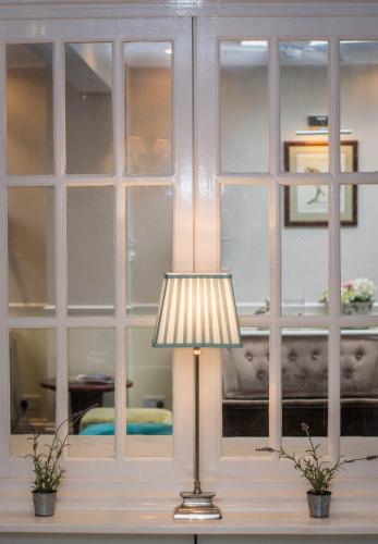 a lamp sitting on a table in front of a window at Beachlands Hotel in Weston-super-Mare