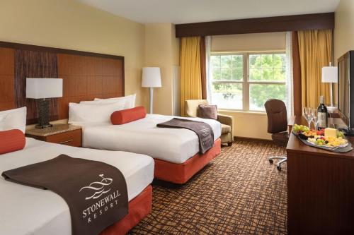 a hotel room with two beds and a window at Stonewall Resort in Roanoke