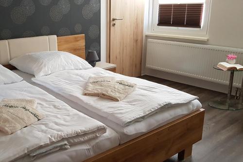 a bedroom with two beds with white sheets and a window at Stolpseeblick in Himmelpfort