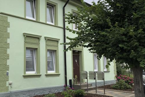 a green building with a door and a tree at Stolpseeblick in Himmelpfort