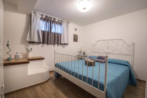 una camera da letto con un letto con lenzuola blu e una finestra di Fabiene Familyholidays Gelsonia a Cefalù