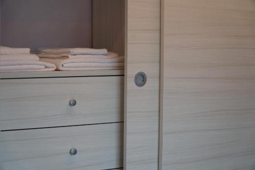 a closet with wooden drawers and towels at Villa Giuseppe Bernabei Guest House in Marino