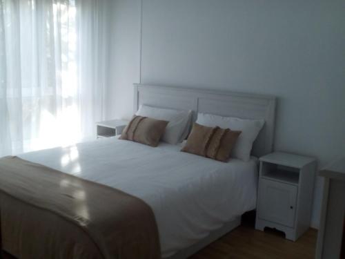 a bedroom with a large white bed with pillows at Precioso, luminoso y cómodo in Castro-Urdiales