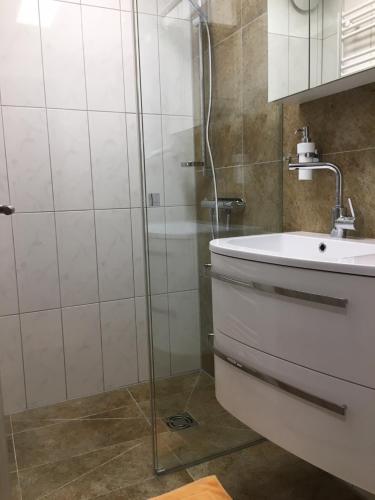 Ferienwohnung bon WAB في هالشتات: حمام مع دش وحوض استحمام ومغسلة