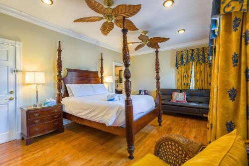 a bedroom with a four poster bed and a couch at Duval Inn - Key West in Key West