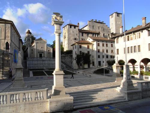 a group of columns in a city with buildings at Via Paradiso 32 in Feltre