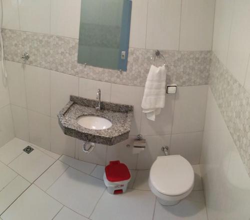 a small bathroom with a toilet and a sink at Casa para famílias, próximo a Basílica de Nossa Senhora Aparecida in Aparecida