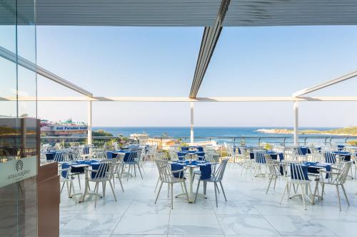 巴利恩的住宿－Atali Grand Resort，一个带桌椅的海景庭院