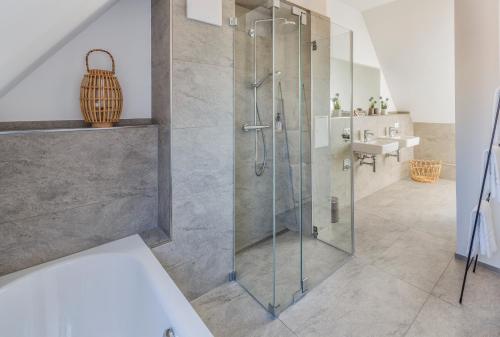 a glass shower in a bathroom with a sink at cosy grey apartments in Freiburg im Breisgau