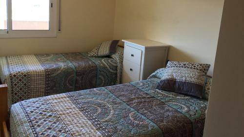 um pequeno quarto com 2 camas e uma cómoda em Golden Beach 208 em Sant Carles de la Ràpita