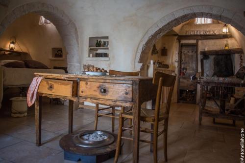 a kitchen with an old wooden table in a room at Rione Pentimi in Alberobello
