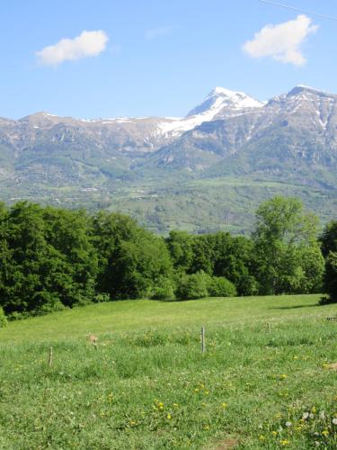 a green field with mountains in the background at Gîte Potimarron in Ancelle