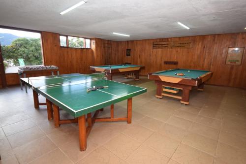 a room with three ping pong tables in it at D'Acosta Hotel Sochagota in Paipa