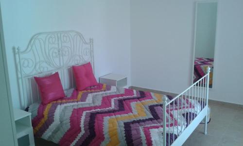 a bedroom with a bed with pink pillows at Casa Almeida in Vimieiro